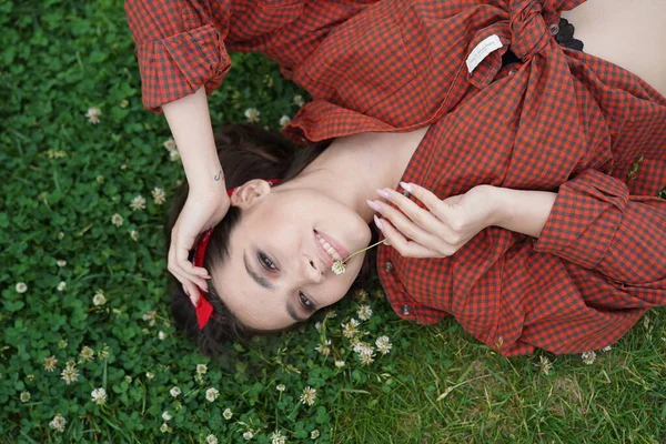 Een meisje ligt op haar rug op het gras — Stockfoto