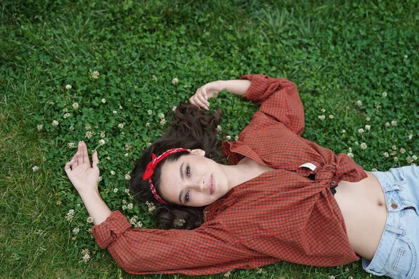 Девочка лежит спиной на траве — стоковое фото