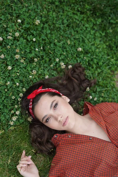 Een meisje ligt op haar rug op het gras — Stockfoto