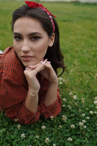 Een meisje ligt op haar rug op het gras — Stockfoto