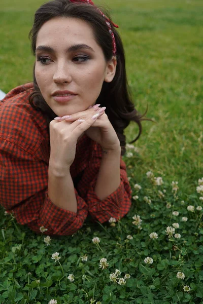 Een meisje ligt op haar rug op het gras — Stockfoto