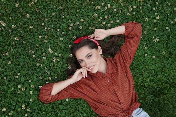 Bir kız çimenlerde sırtüstü yatıyor — Stok fotoğraf