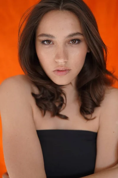 Jeune femme les yeux ouverts sur fond blanc. Gros plan d'une fille souriante regardant une caméra en studio. cheveux bouclés mannequin visage souriant. Portrait de fille joyeuse les yeux ouverts. Femme nature beauté — Photo