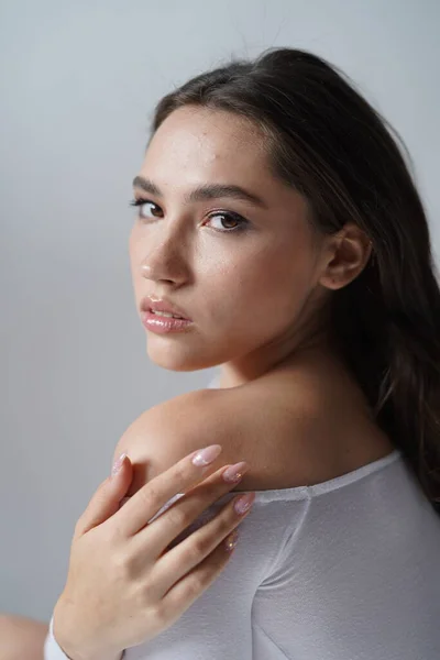 Jeune femme les yeux ouverts sur fond blanc. Gros plan d'une fille souriante regardant une caméra en studio. Femme nature beauté — Photo