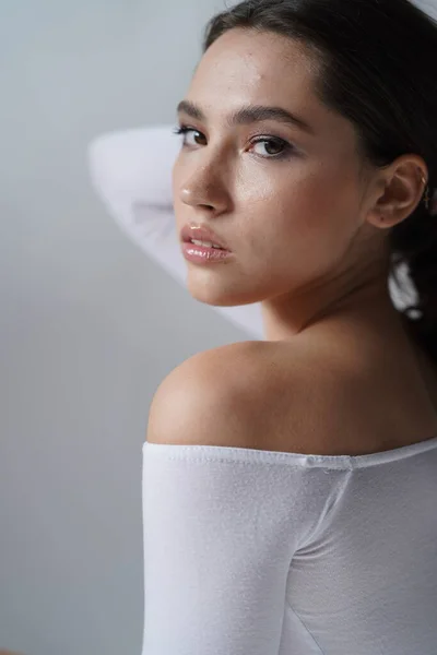 Jeune femme les yeux ouverts sur fond blanc. Gros plan d'une fille souriante regardant une caméra en studio. Femme nature beauté — Photo