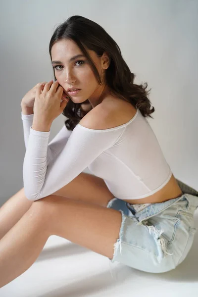 Jovem mulher olhos abertos no fundo branco. Close up de menina sorridente olhando para a câmera no estúdio. Natureza feminina beleza — Fotografia de Stock