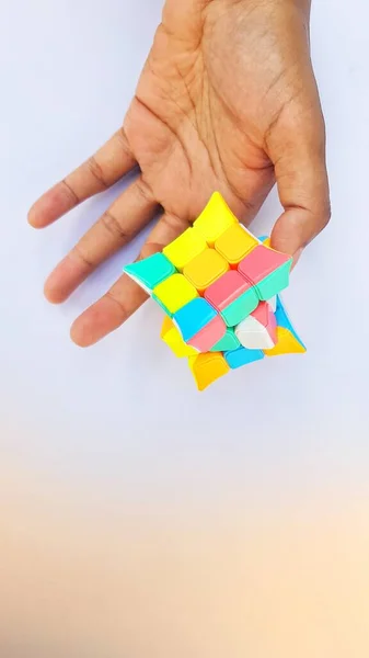 Business Concept and puzzle cubes Ideas Creative built from blocks of decision making process logical thinking. Logical tasks.Hand holding Box puzzle element on Blue - Orange paper background