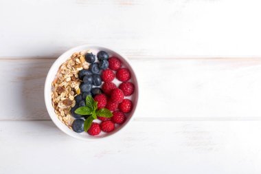 Güler yüzlü kase yoğurt, taze meyveler ve tahıl. Beslenme diyet için sağlıklı kahvaltı