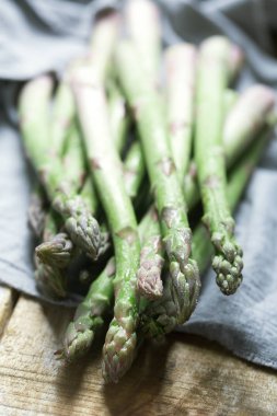 Taze yeşil kuşkonmaz ve domates ahşap arka plan üzerinde Banches. Rustik tarzı, dikey yönlendirme