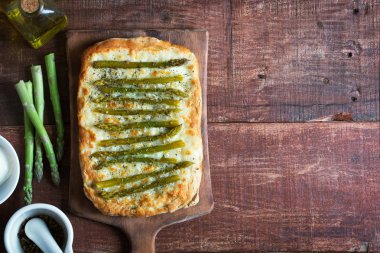 Otlar ve mozzarella ahşap rustik zemin üzerine yeşil kuşkonmaz pizza