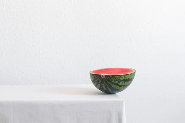 Die Hälfte der Wassermelone auf einem weißen Tisch mit Kopierraum — Stockfoto