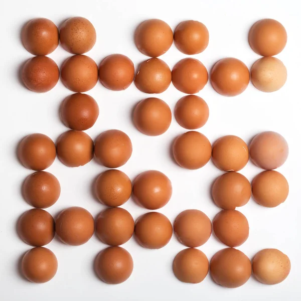 Візерунок з коричневих яєць на білому тлі. Концепція їжі — стокове фото