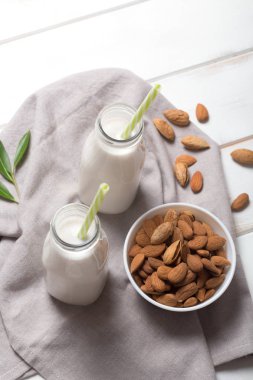 Beyaz ahşap bir masa üzerinde badem sütü