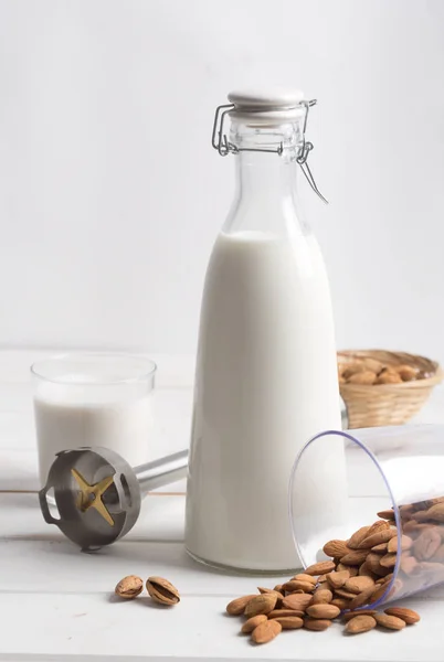 Latte di mandorla su un tavolo di legno bianco — Foto Stock