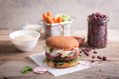 Bir vejetaryen burger yapmak için pişmiş fasulye ve kinoa bir karıştırıcıda birleştirin ve bir pirzola yapın. Bir rulo karıştırın ve bir pirzola ve taze sebzeler bir sürü koymak. Doğal Yunan yoğurt ekleyin