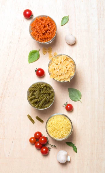 Different types of Italian pasta with vegetables on the table — Stock Photo, Image