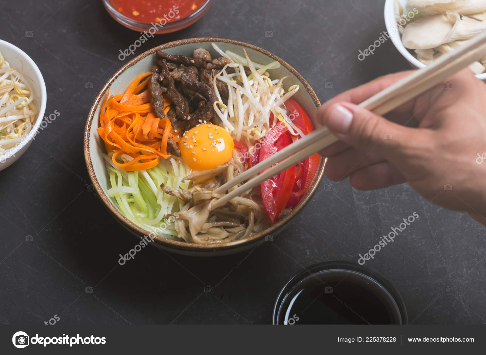 Traditional Asian Bibimbap dish with rice and vegetables on dark