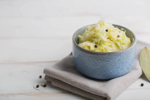 Sauerkraut in a blue bowl on a wooden table — Stock Photo, Image