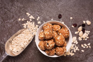 Sağlıklı organik enerji granola Koza ile fındık, kakao, yulaf ve kuru üzüm - vejetaryen tatlı şeker ısırır. Koyu arka plan, üstten görünüm