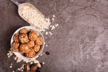Sağlıklı organik enerji granola Koza ile fındık, kakao, yulaf ve kuru üzüm - vejetaryen tatlı şeker ısırır. Koyu arka plan, üstten görünüm