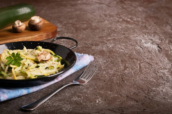 Padella di spaghetti preparata con sugo di zucchine e funghi sul tavolo di legno — Foto Stock