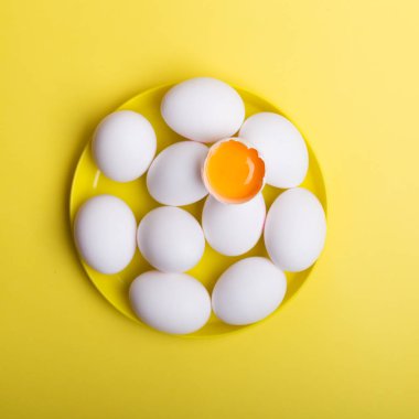 Beyaz yumurta ve bir plaka sarı zemin üzerine bozuldu