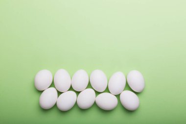 Beyaz yeşil arka plan üzerinde yumurta. Üstten görünüm, kavram