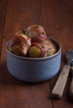 Izgara bebek patates pastırma ahşap masa üzerinde sarılı. Rustik tarzı, dikey yönlendirme