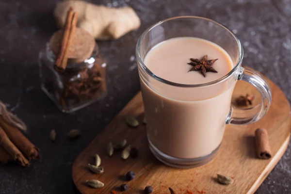Masala chai-te på den mörka bakgrunden. Heta indiska dryck med kryddor — Stockfoto