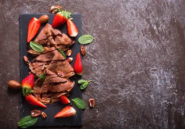Traditional French crepes cooked with chocolate. Decorated with mint and strawberries