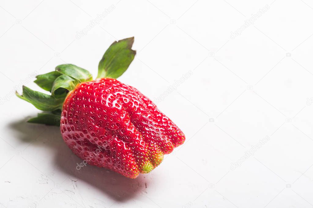 Ugly organic home grown strawberries isolated on white
