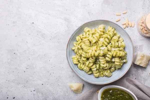 Plate of pasta fusilli with pesto sauce on gray concrete background — Stock Photo, Image