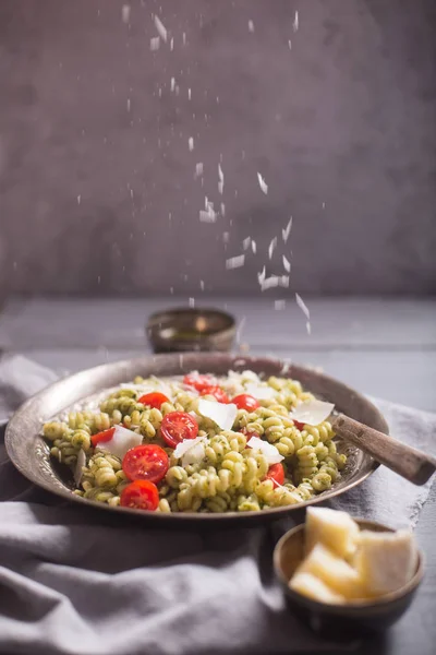 Placa de massa fusilli com molho de pesto em fundo de madeira cinza — Fotografia de Stock