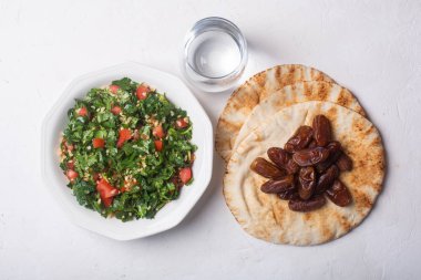 Tabbouleh salata, ekmek, tarihler ve su-iftar için geleneksel Orta Doğu veya Arap çanak
