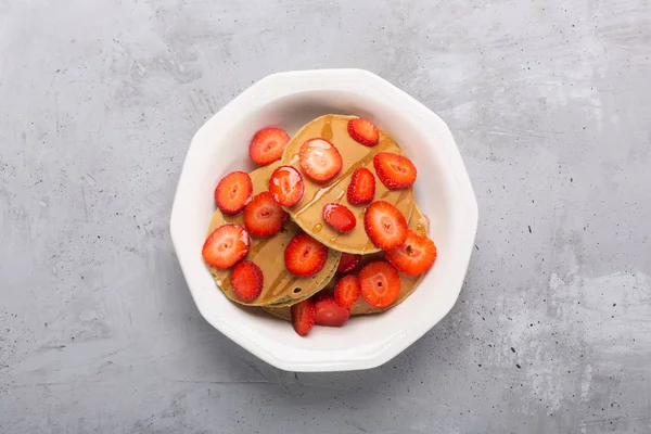 Zelfgemaakte pannenkoeken met aardbeien en boter. Klaar voor het ontbijt. Platte lay, bovenaanzicht — Stockfoto