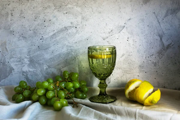 회색 배경에 포도, 레몬, 물과 함께 하는 정물 — 스톡 사진