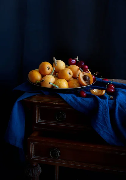 Still life with fresh medlar and cherry on the metallic plate — Stock Photo, Image