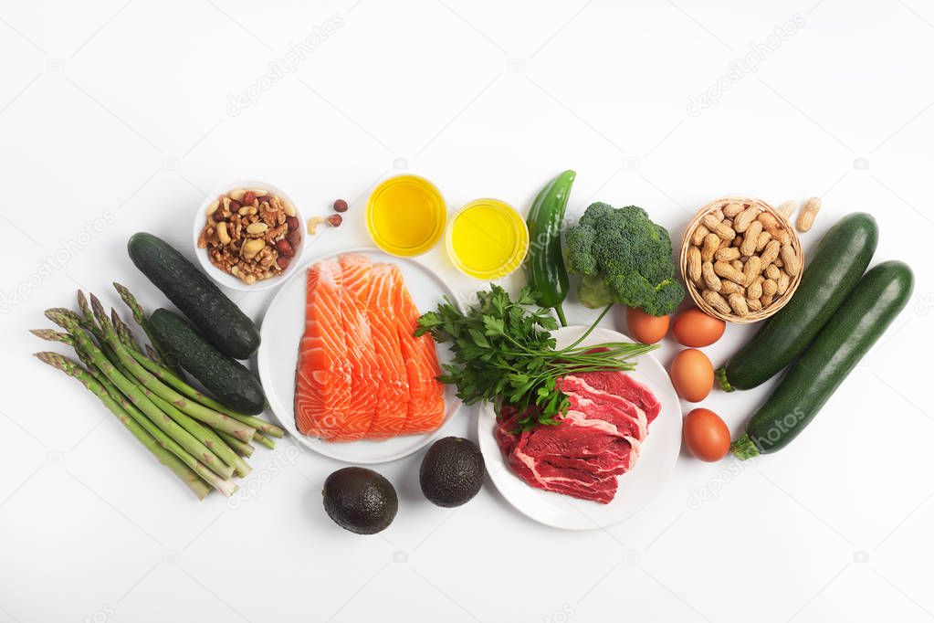 Ketogenic, keto diet, including vegetables, meat and fish, nuts and oil on white background