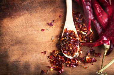 Ahşap arka plan üzerinde baharatlı kesilmiş Chili peper karışımı