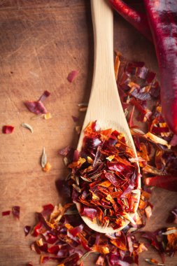Ahşap arka plan üzerinde baharatlı kesilmiş Chili peper karışımı