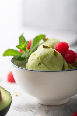 Ahududu ile bir kase içinde ev yapımı organik avokado ve nane dondurma