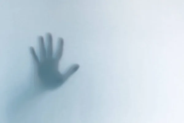Koncentrált ijesztő szellem keze mögött egy fehér üveg háttér — Stock Fotó