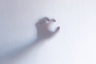 Beyaz cam arka plan arkasında korkunç hayalet eller defocused