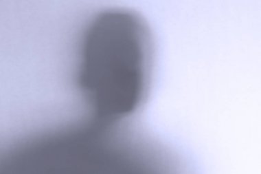 Beyaz cam arka plan arkasında defocused korkutucu hayalet yüz
