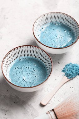 Mavi çay matcha bir kase ve beton yüzeyinde chasen