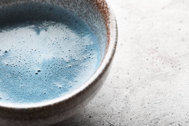 Mavi çay matcha bir kase ve beton yüzeyinde chasen