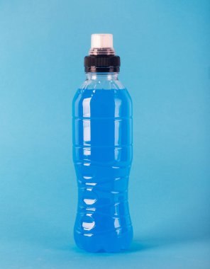 İzotonik enerji içeceği. Mavi şeffaf sıvı ile Şişe, renkli bir arka plan üzerinde spor içecek