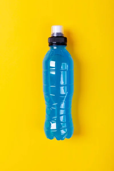 Bebida energética isotónica. Garrafas com líquido transparente azul, bebida esportiva em um fundo amarelo — Fotografia de Stock