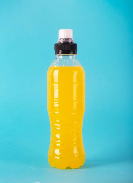 Isotonic energy drink. Bottle with yellow transparent liquid, sport beverage on a colorful background — Stock Photo, Image