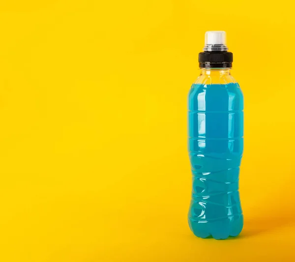 Bebida energética isotónica. Garrafas com líquido transparente azul, bebida esportiva em um fundo amarelo — Fotografia de Stock